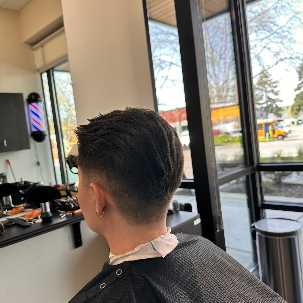 Skin fade blended into a textured scissor cut on top, by the window at European Barber in Redmond